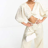 Collective The Label Exclusive Twisted Cut-Out Jumpsuit In Oyster – jumpsuits & playsuits by Collective The Label, available to rent from Hirestreet