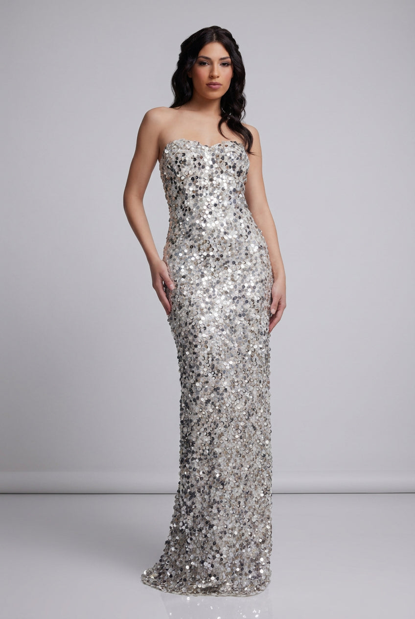 Woman wearing a silver sequin gown on a white background